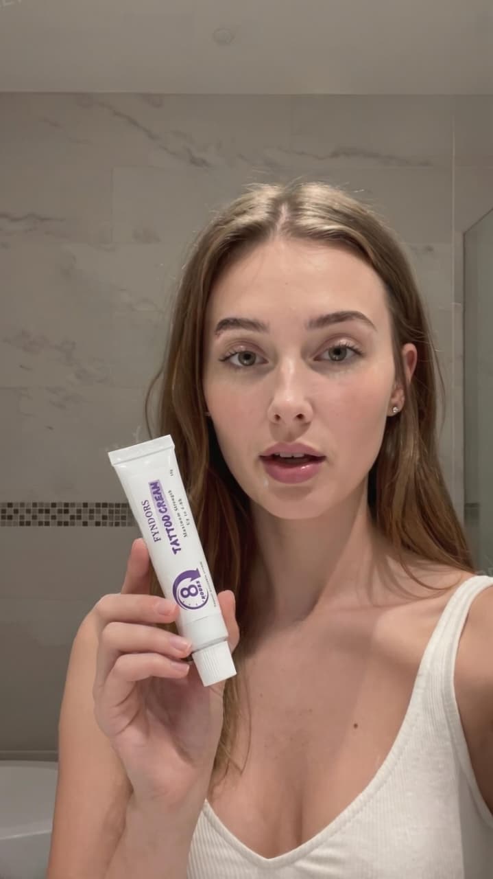 Tattooed model holding MIRASCA numbing cream